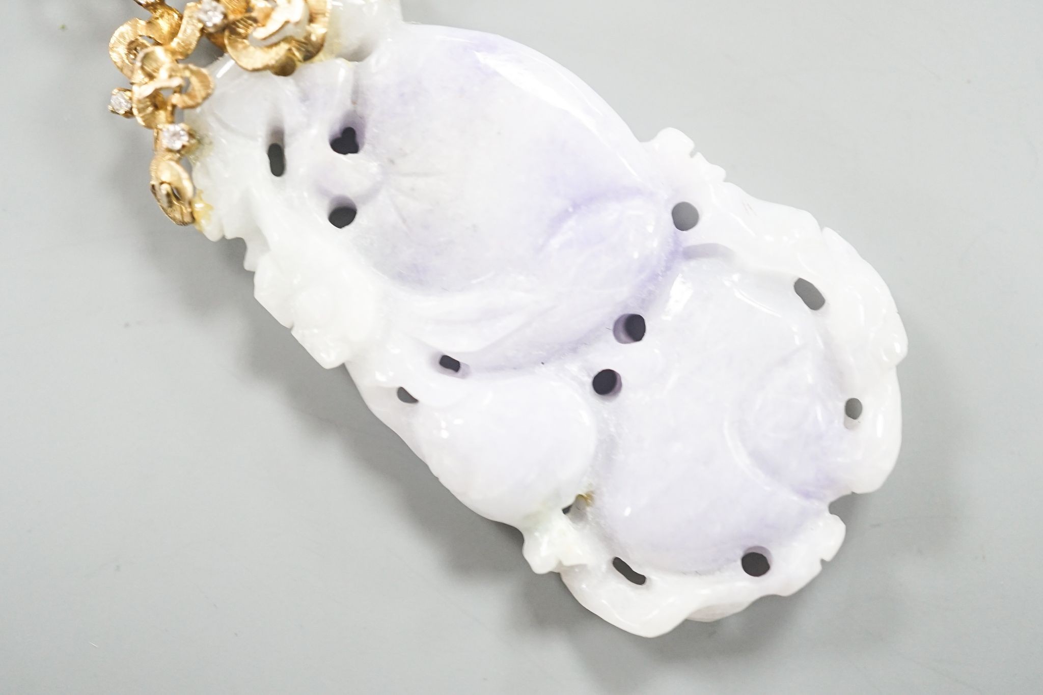 A 14k yellow metal mounted carved jade and diamond chip set pendant, overall 66mm, gross weight 19.4 grams.